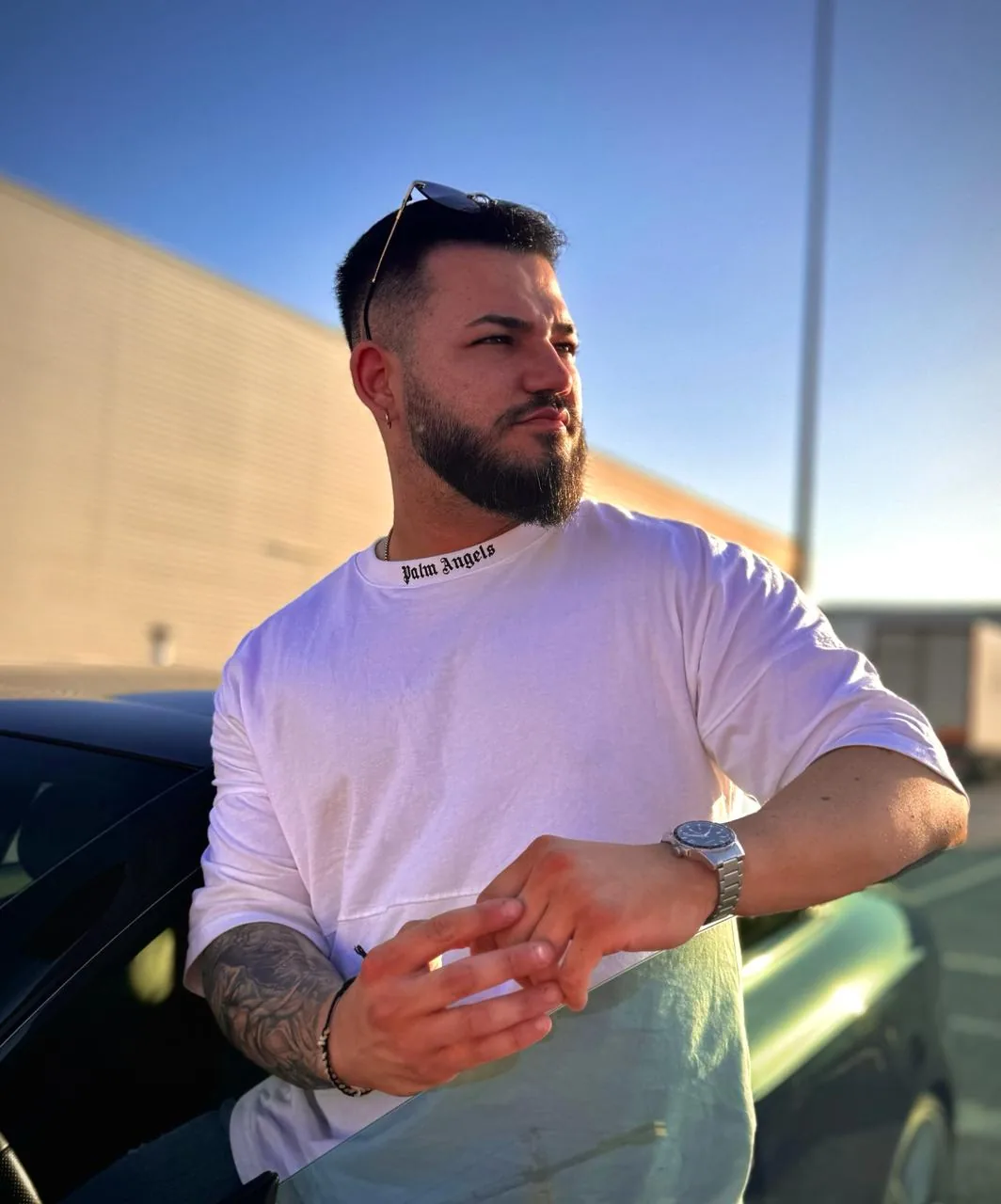 Jesús Vázquez Gutiérrez, fundador de Ads & Management, apoyado en un coche con una nave industrial al fondo